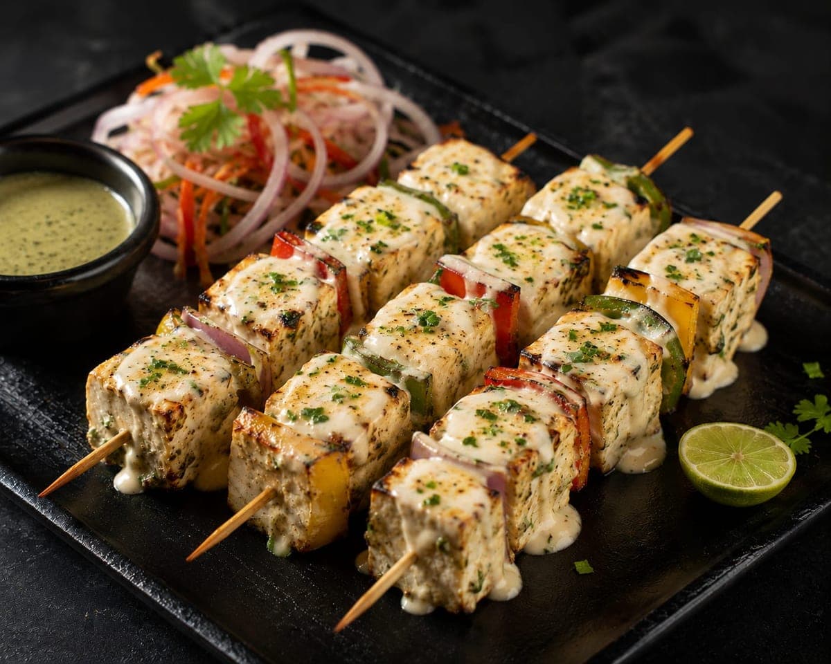Creamy grilled paneer and pepper skewers served with salad and green dip